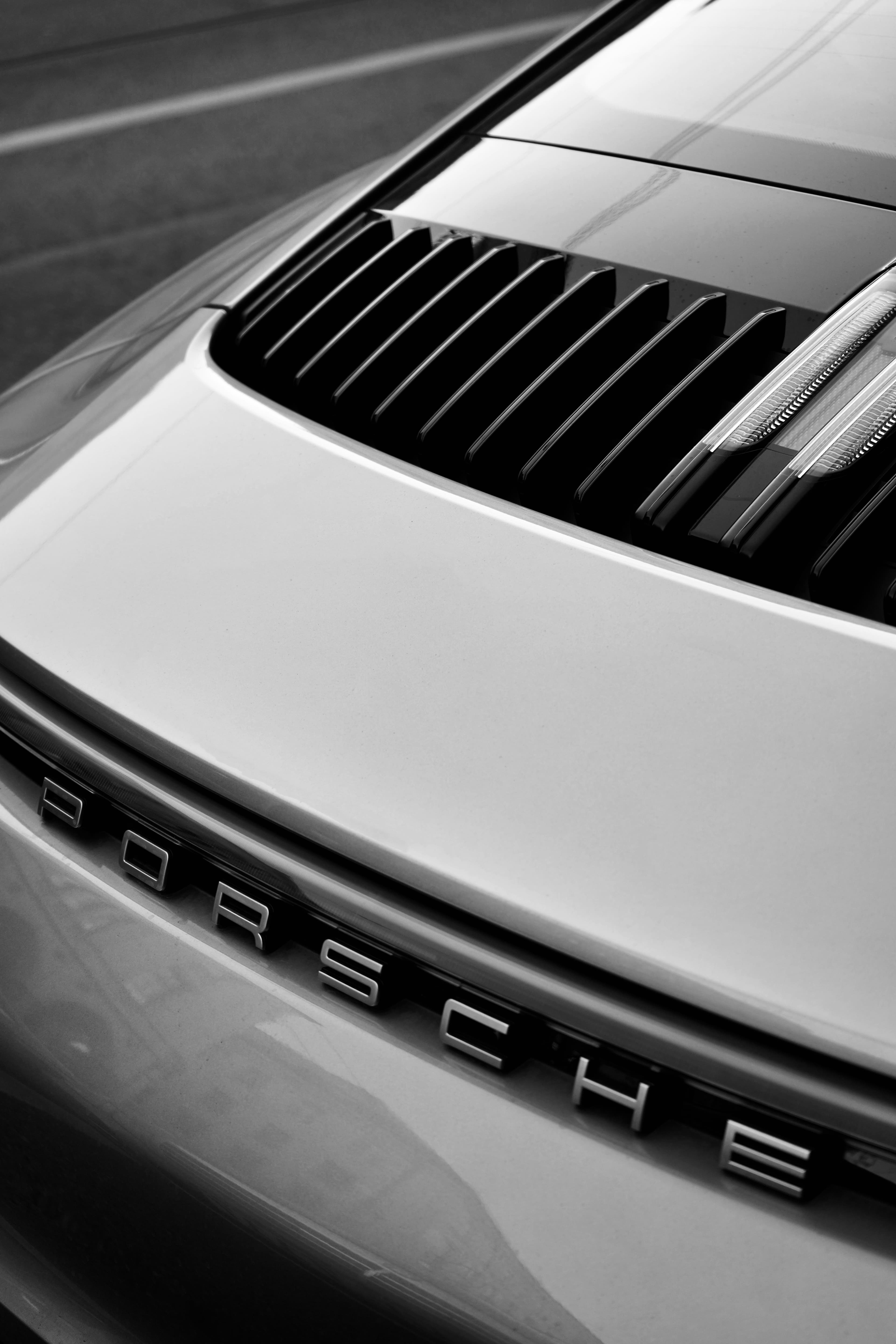 Detail of a Porsche hood and badge, black and white